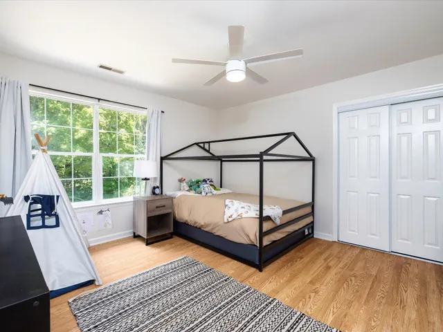 a view of a house with a yard and a large tree
