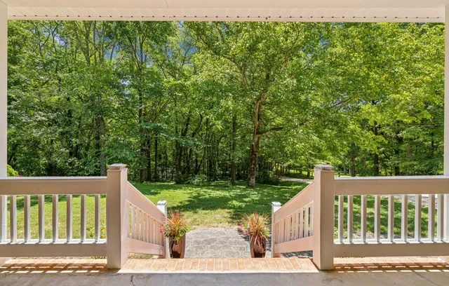 a view of a house with a yard and potted plants