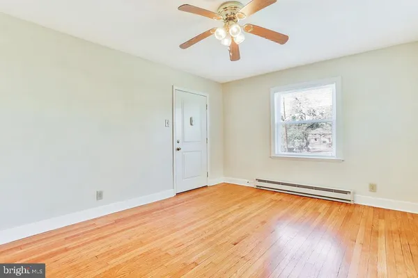 an empty room with a window and a fan