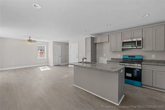 a kitchen with kitchen island a sink stainless steel appliances and white cabinets