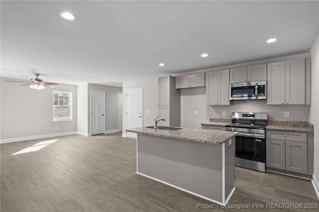 1010 Saunders Avenue Aberdeen, NC 28315 - Photo 16 of 44 a kitchen with stainless steel appliances granite countertop a stove a sink and a refrigerator