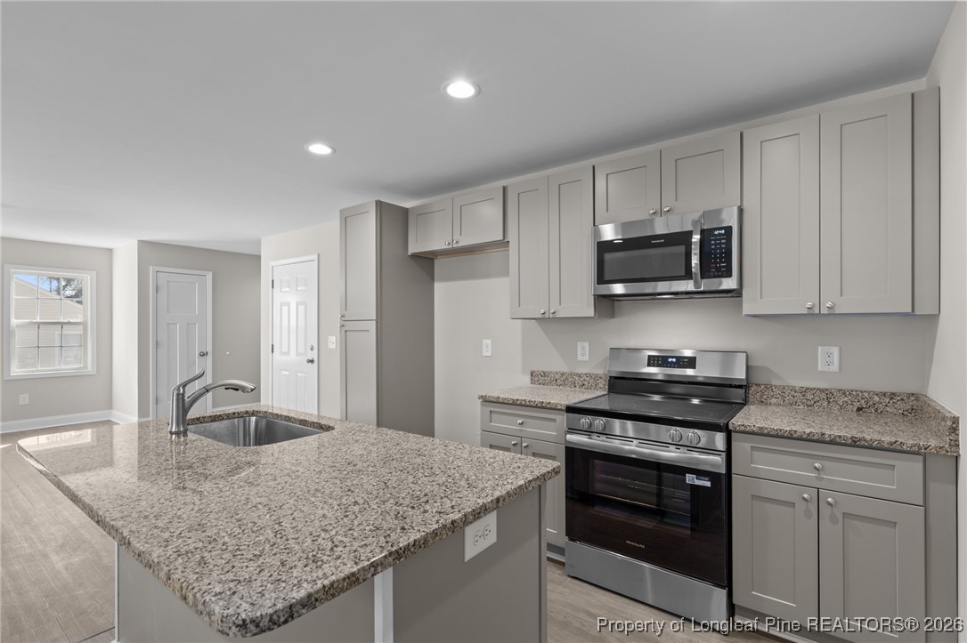 1010 Saunders Avenue Aberdeen, NC 28315 - Photo 17 of 44 a kitchen with stainless steel appliances granite countertop a sink stove and refrigerator