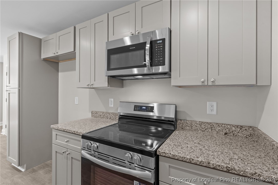 1010 Saunders Avenue Aberdeen, NC 28315 - Photo 18 of 44 a kitchen with stainless steel appliances granite countertop white cabinets and a stove top oven