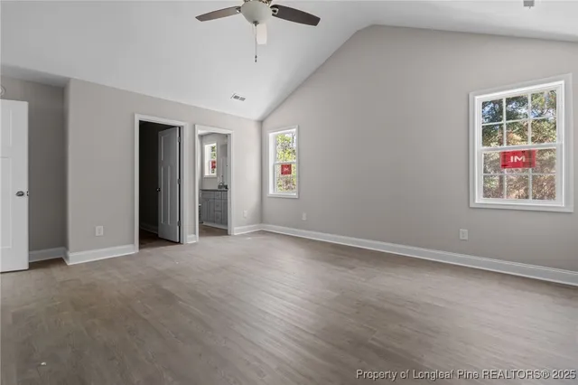 an empty room with windows and ceiling fan