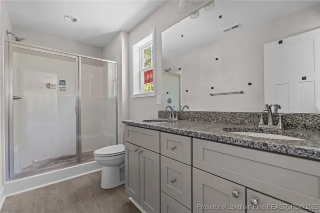 a bathroom with a granite countertop sink toilet and shower