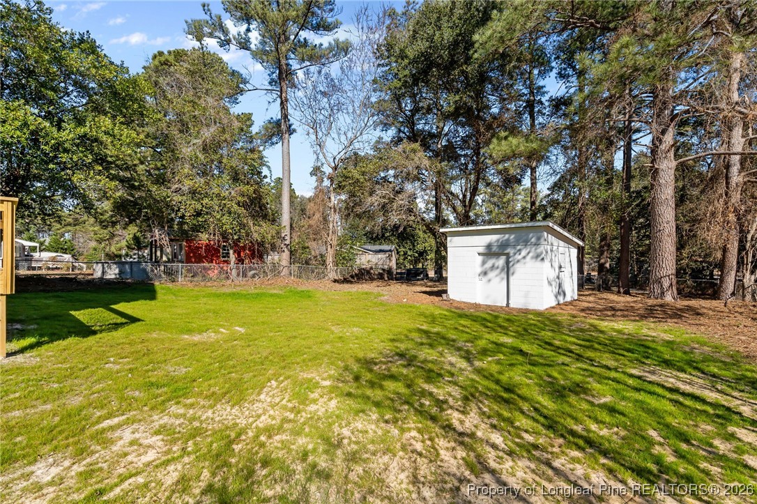 1010 Saunders Avenue Aberdeen, NC 28315 - Photo 41 of 44 a yellow house with trees in front of it