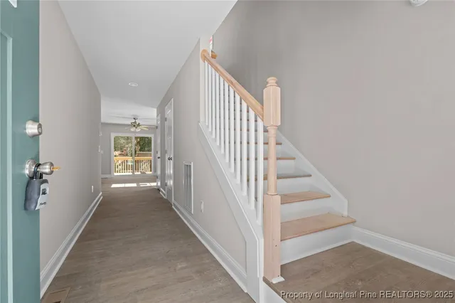 a view of a hallway with wooden floor and entryway