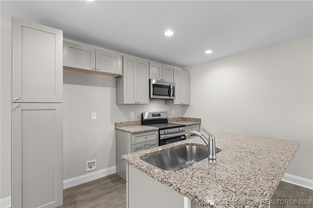 1010 Saunders Avenue Aberdeen, NC 28315 - Photo 10 of 44 a kitchen with a sink a stove and refrigerator