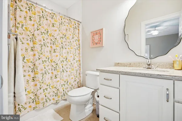 a bathroom with a granite countertop sink toilet mirror and shower