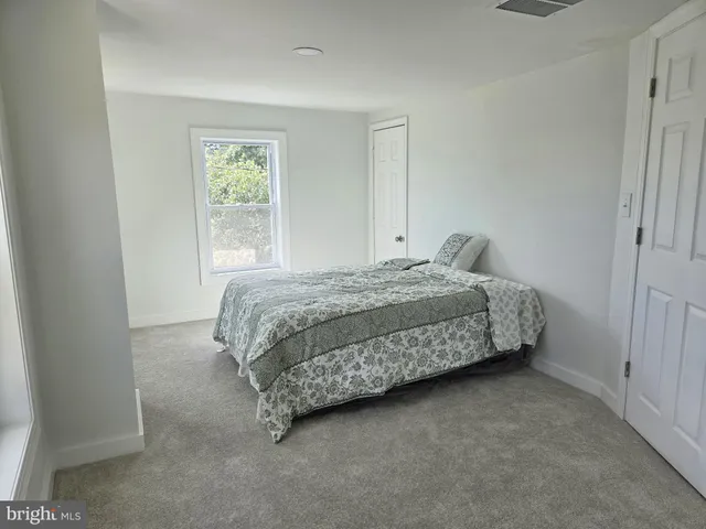 a bedroom with a bed next to a window