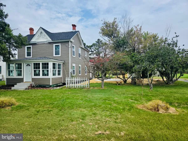 a view of a house with a yard and sitting area