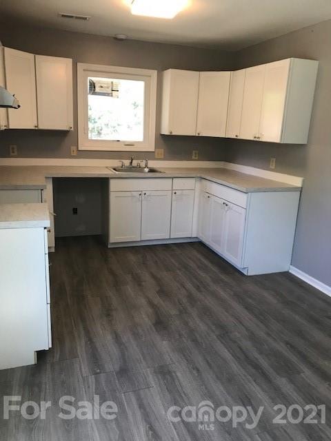 6718 Idlewild Road Charlotte, NC 28212 - Photo 4 of 12 a kitchen with wooden floors and white appliances