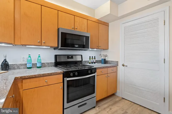 a kitchen with stainless steel appliances granite countertop white cabinets sink and a granite counter top