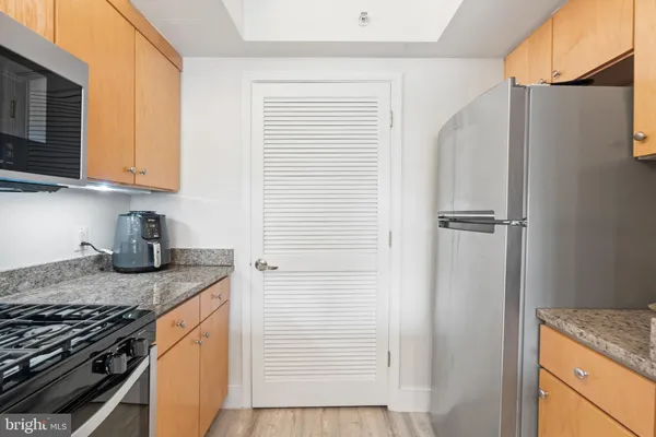 a kitchen with stainless steel appliances granite countertop a sink stove and cabinets