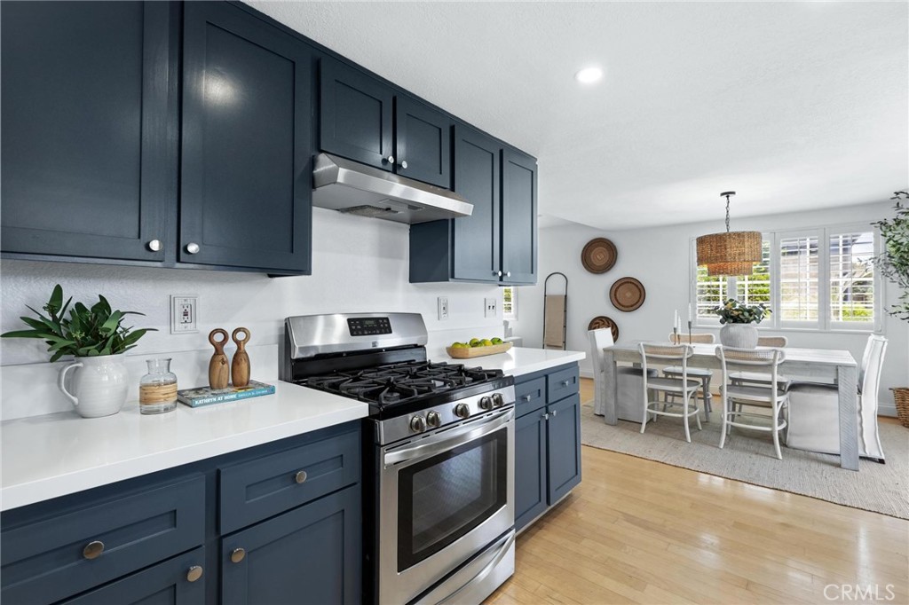 1421 12th Street, Unit 1 Manhattan Beach, CA 90266 - Photo 12 of 36 a kitchen with stainless steel appliances a sink a stove a table and chairs