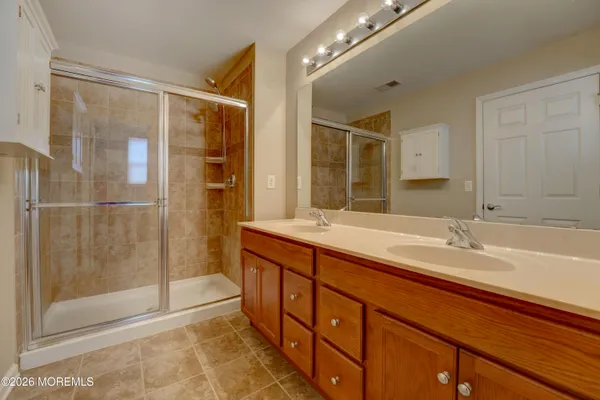a spacious bathroom with a shower sink and mirror