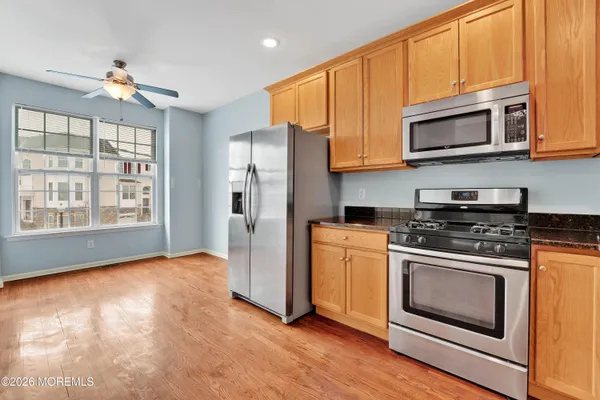 a kitchen with stainless steel appliances granite countertop a stove a refrigerator and a microwave