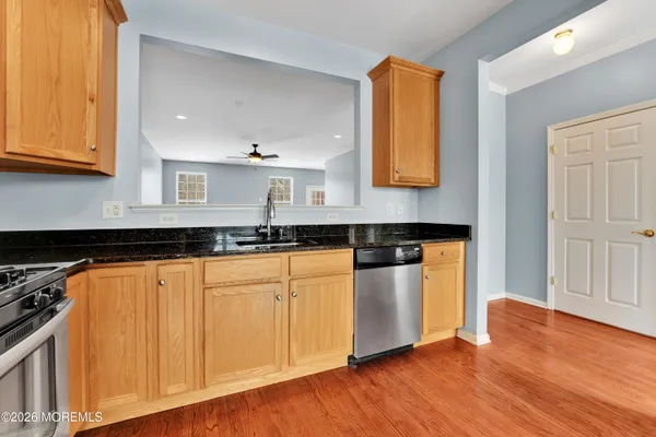a kitchen with stainless steel appliances granite countertop a stove a sink and a microwave