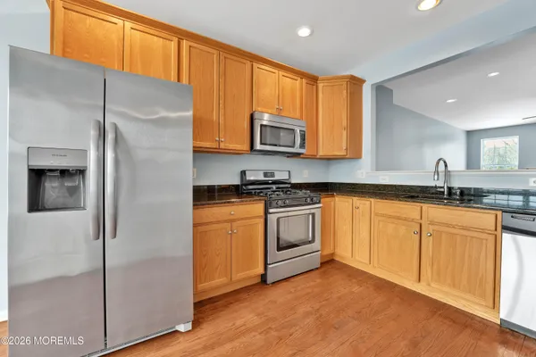 a kitchen with stainless steel appliances granite countertop a refrigerator sink and microwave