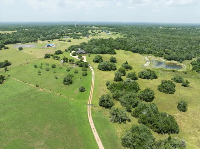 an aerial view of residential houses with outdoor space and trees