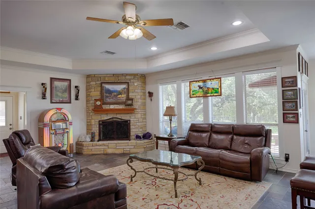 a living room with furniture a fireplace and a large window