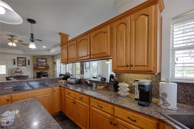 a kitchen with granite countertop a sink a counter space cabinets and stainless steel appliances