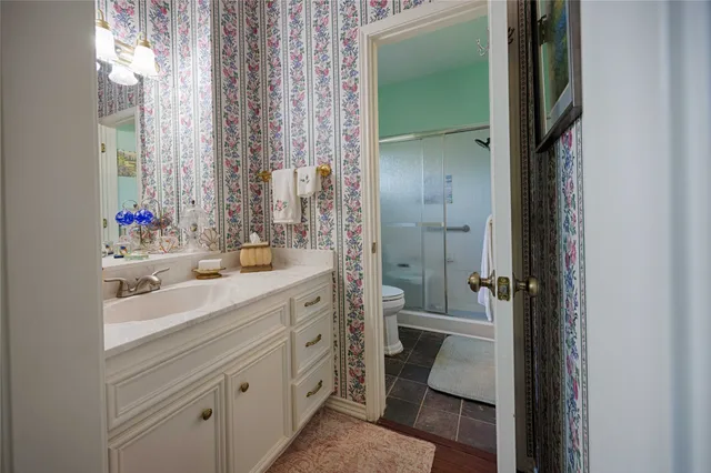 a bathroom with a double vanity sink toilet and shower