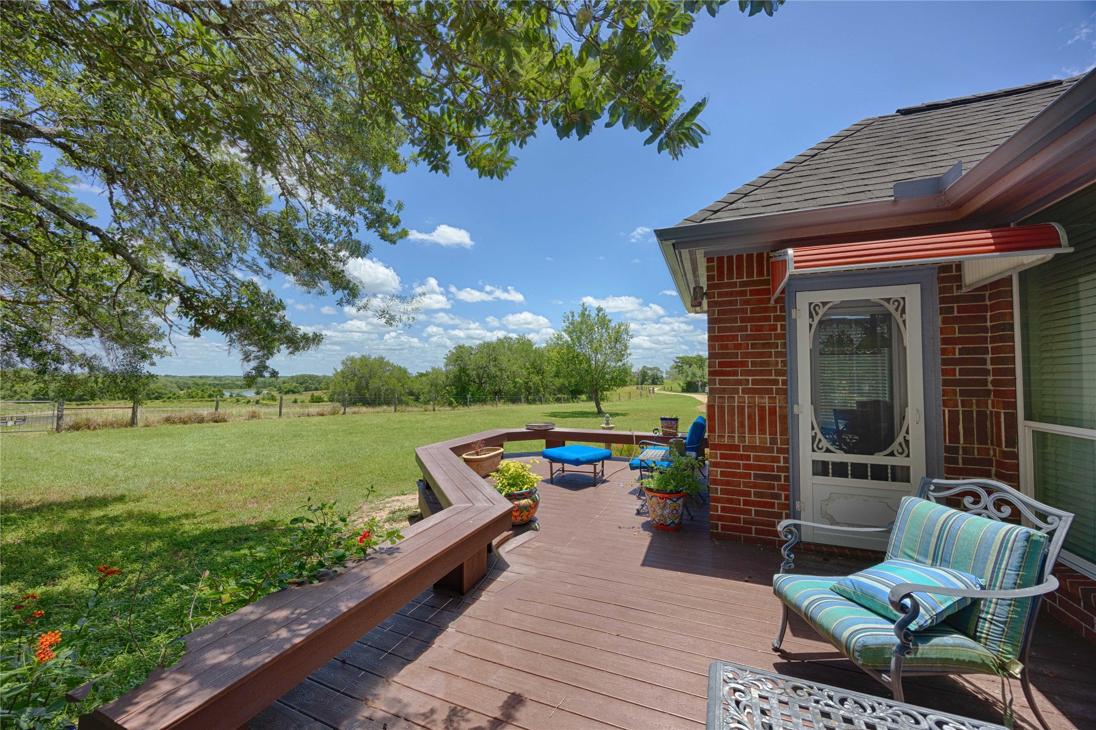 900 Schulze Road Muldoon, TX 78949 - Photo 30 of 47 a view of a deck with couches table and chairs under an umbrella