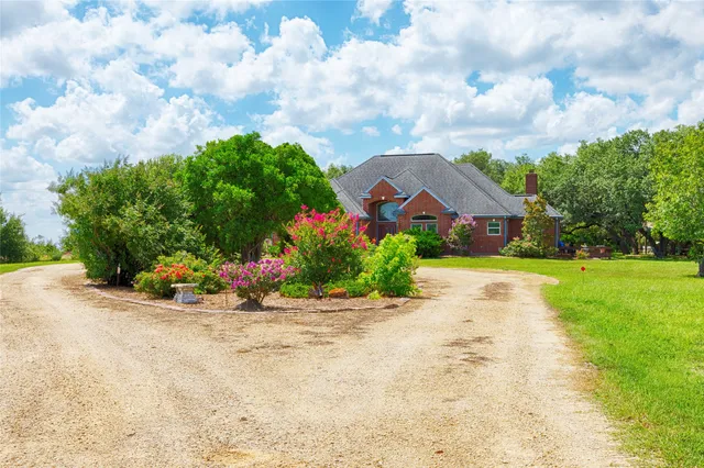 a view of a house with a big yard and potted plants