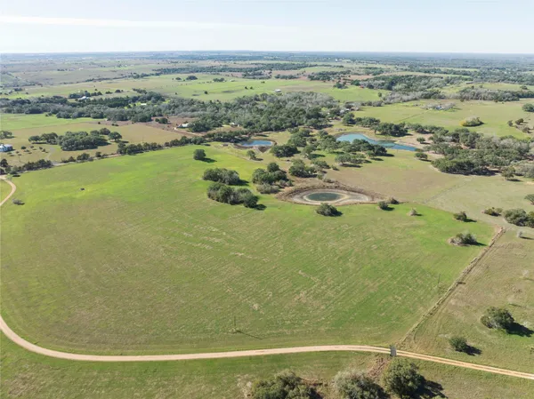 a view of a house with a big yard and potted plants