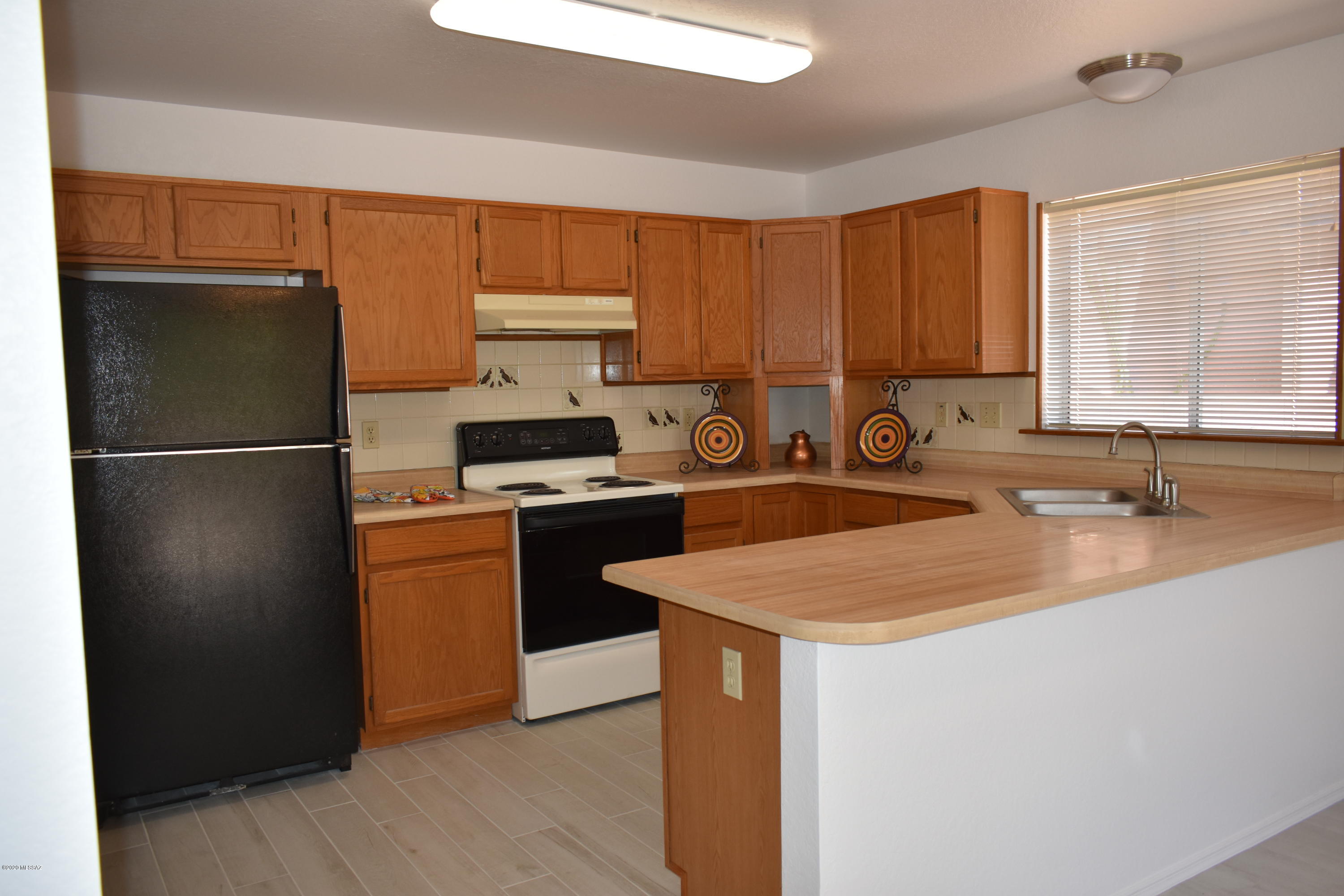 3504 West Sky Ridge Loop Tucson, AZ 85742 - Photo 5 of 13 a kitchen with stainless steel appliances a refrigerator sink and cabinets