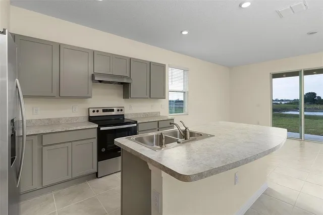 a kitchen with a sink a stove and cabinets