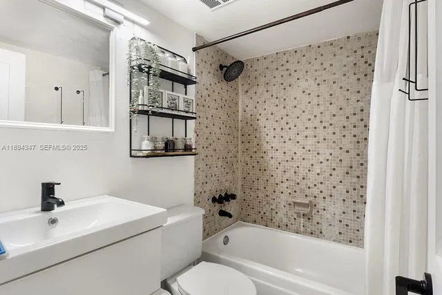 a bathroom with a bathtub shower sink and toilet