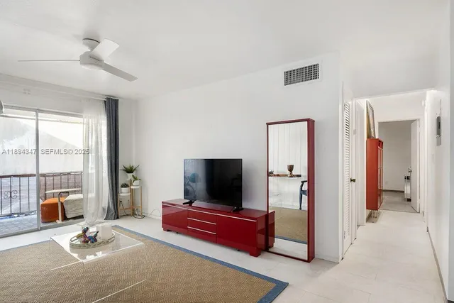 a living room with furniture flat screen tv and floor to ceiling window
