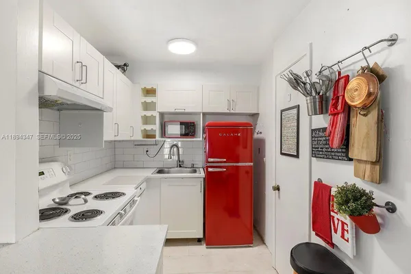 a kitchen with stainless steel appliances granite countertop a sink a stove and a refrigerator