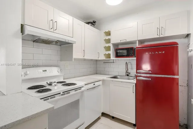 a kitchen with stainless steel appliances white cabinets and a refrigerator
