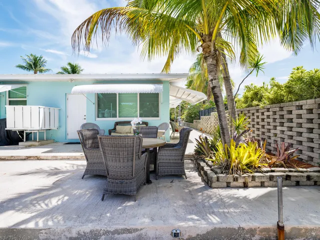 a view of a house with backyard and sitting area