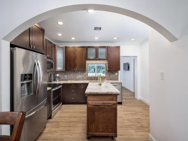 a kitchen with stainless steel appliances granite countertop a sink stove and refrigerator