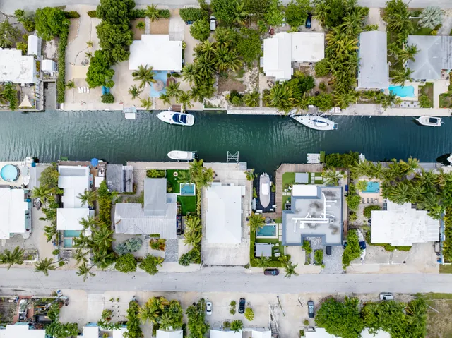 a front view of a house with a yard and potted plants