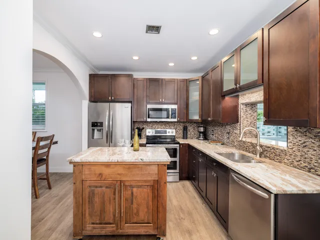 a kitchen with kitchen island granite countertop a sink stove and refrigerator