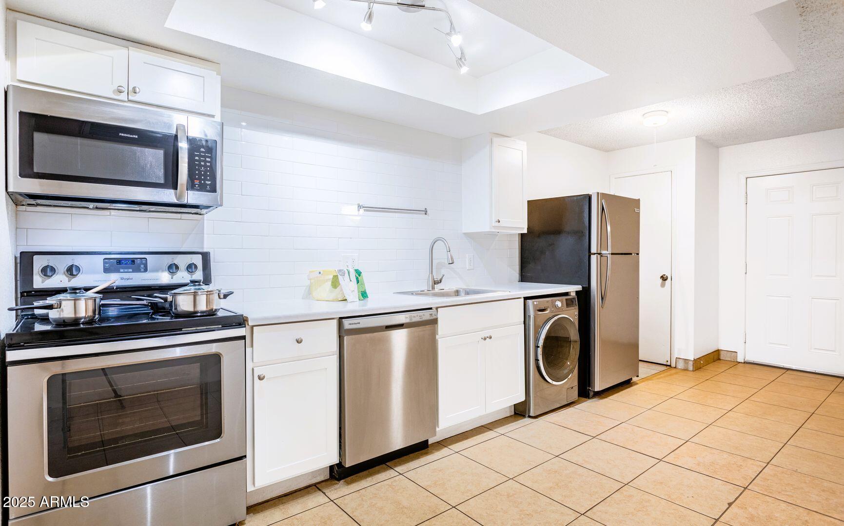 a kitchen with stainless steel appliances a stove microwave and refrigerator
