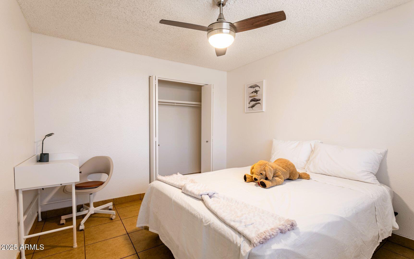 1623 West Missouri Avenue, Unit 1 Phoenix, AZ 85015 - Photo 5 of 12 a bedroom with a bed and a chandelier