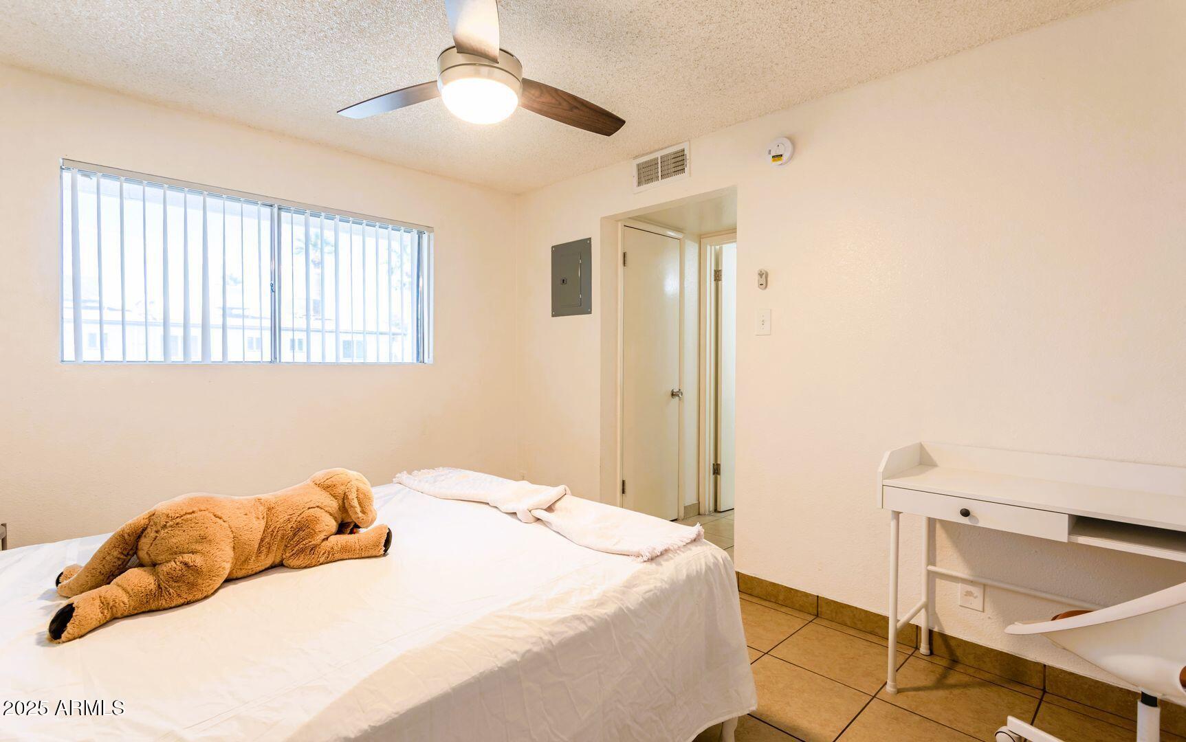 1623 West Missouri Avenue, Unit 1 Phoenix, AZ 85015 - Photo 6 of 12 a bedroom with a bed and a chandelier