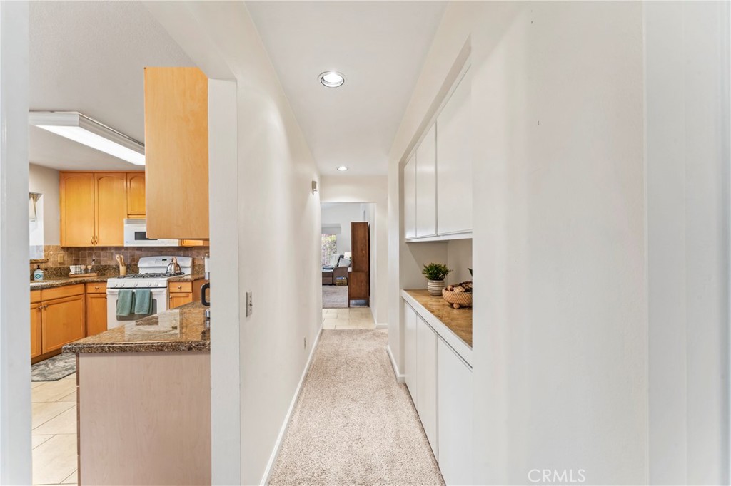 14720 Marymount Street Moorpark, CA 93021 - Photo 15 of 22 a hallway with a sink and a refrigerator
