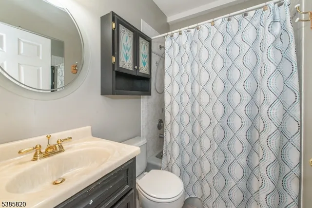 a bathroom with a sink a toilet and shower curtain