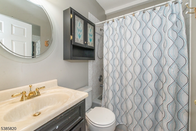 40 Castle Rock Road Lake Hopatcong, NJ 07849 - Photo 19 of 20 a bathroom with a sink a toilet and shower curtain