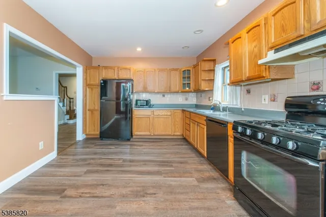 a large kitchen with stainless steel appliances granite countertop a stove and a refrigerator