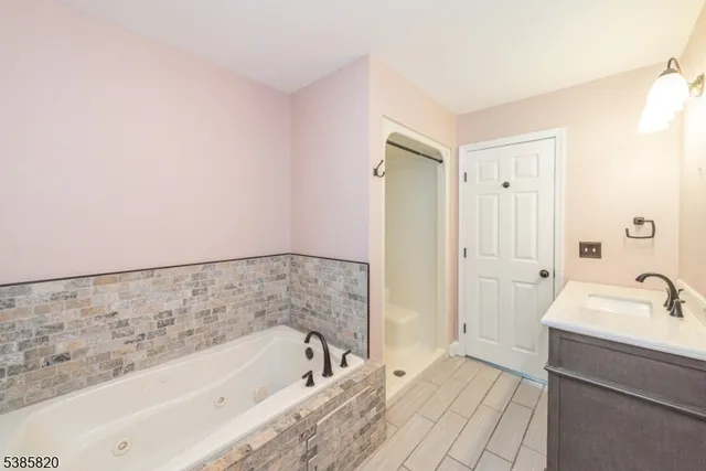 a bathroom with a tub sink and mirror