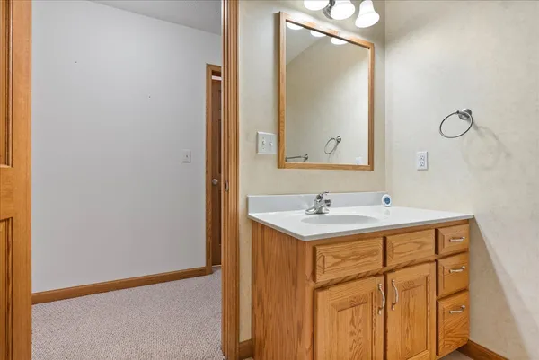 a bathroom with a sink a light fixture and a mirror