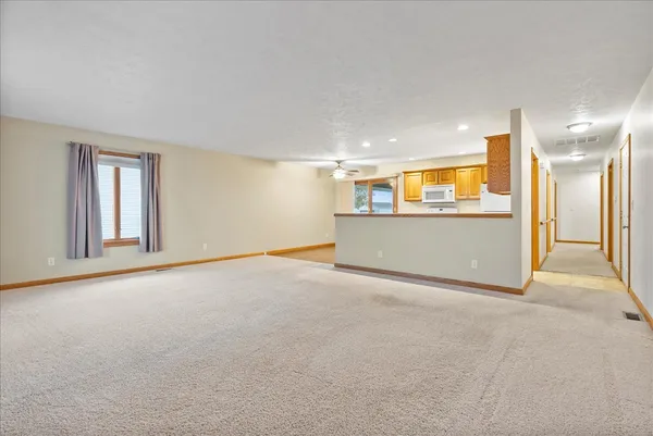 a view of a big room with wooden floor and windows